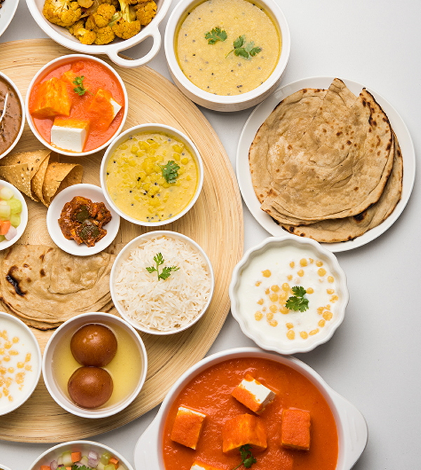 A vegetarian thali of rotis, dal, rice, raita, and paneer curry